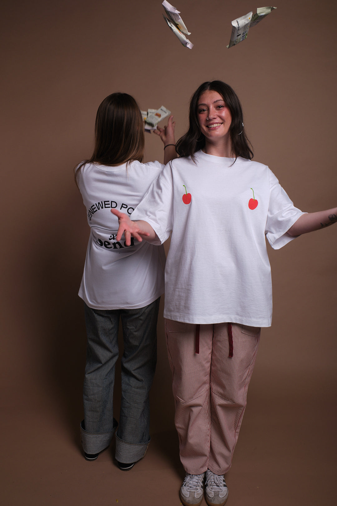 Two people wearing SEND and Renewed Poppy's limited edition t-shirt with SEND's cherry design. 