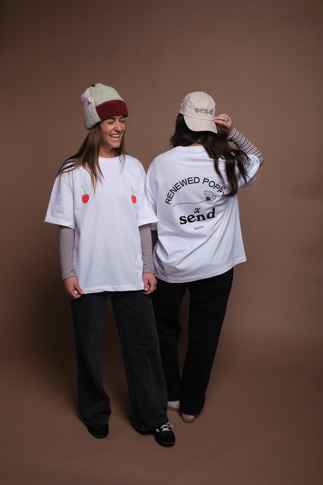 Two people wearing SEND and Renewed Poppy's limited edition t-shirt with SEND's cherry design. 
